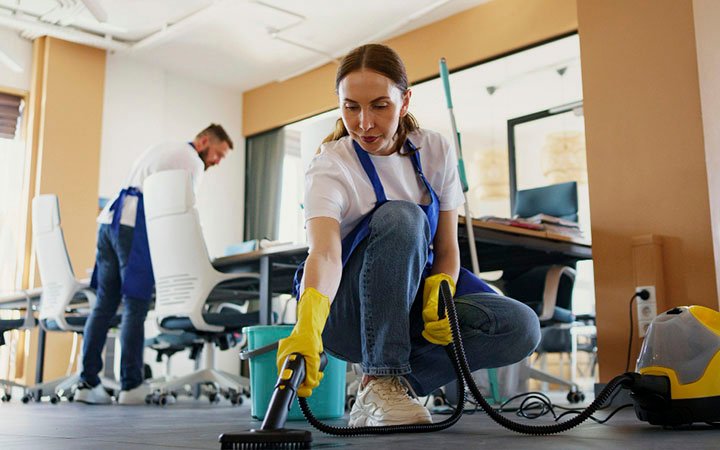 limpeza_0000_pessoa-de-servico-de-limpeza-profissional-usando-aspirador-de-po-no-escritorio-1